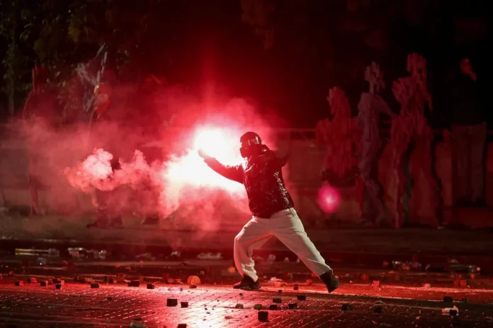 A demonstrator swings a flare amid clashes during an anti-government protest by students in Tirana, Albania, October 17, 2026. REUTERS/Louisa Gouliamaki