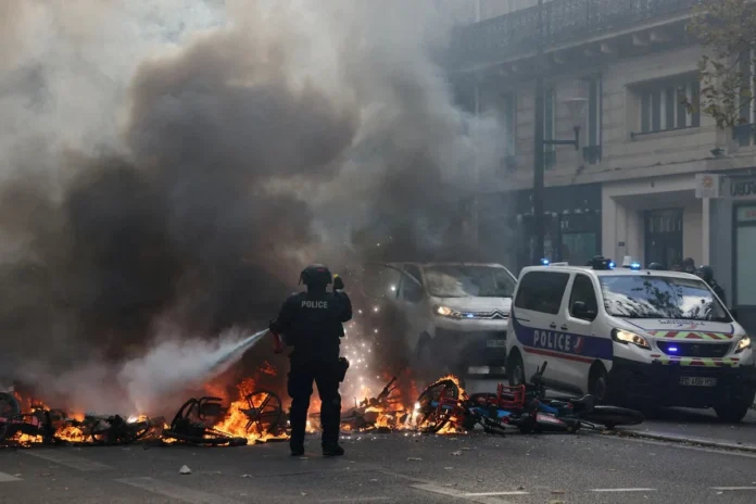 A French police officer extinguish burning bicycles during a demonstration against the cost of living and rising fuel prices in Paris, France, October 17, 2026. REUTERS/Jack Taylor/File Photo